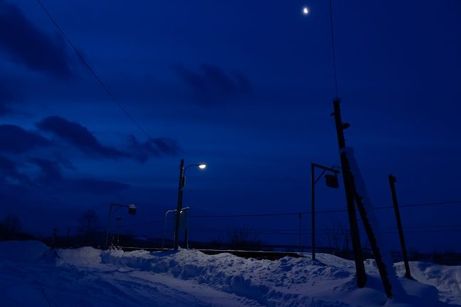 凍てつく真冬の早朝 月光の下、無人の駅を照らし出す灯りには、どこか、温もりがある