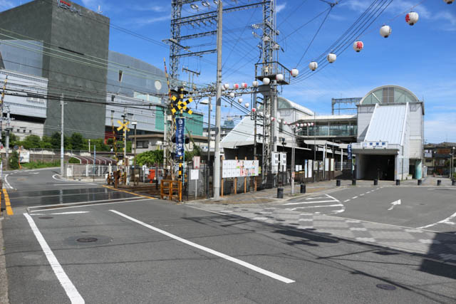 駅の南側を渡る道路が急カーブを描く先にJR関西本線が並行している
