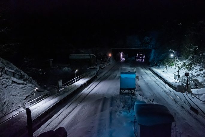 信号に青く照らされて列車の通過を待つ小幌駅