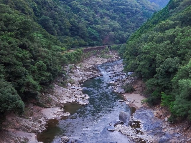 下り線ホームから眺める保津川と嵯峨野観光鉄道の鉄路