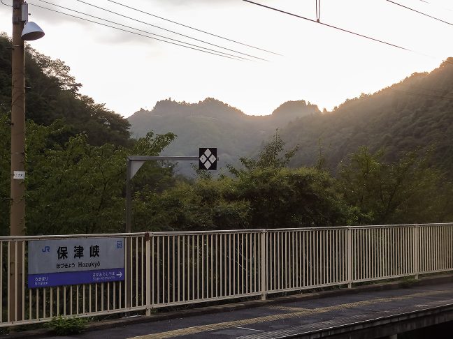 京都市街地への府道が遥か彼方の書物岩の稜線に見える