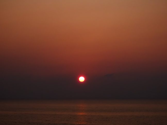 遮るもののない海原に夏の夕日が沈んでいく
