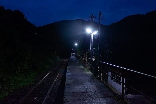 無人の駅を明かりが照らし続ける
