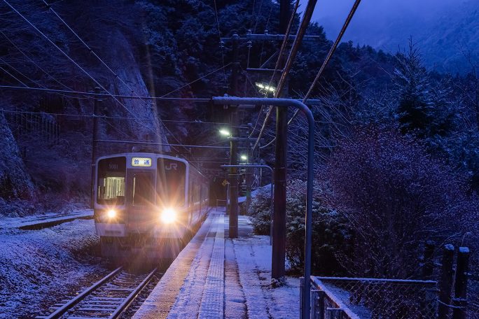 雪が舞う中、始発列車は小和田駅を出発していく