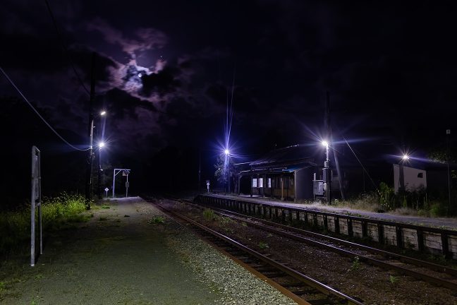 月影さやかな駅構内で一人佇む