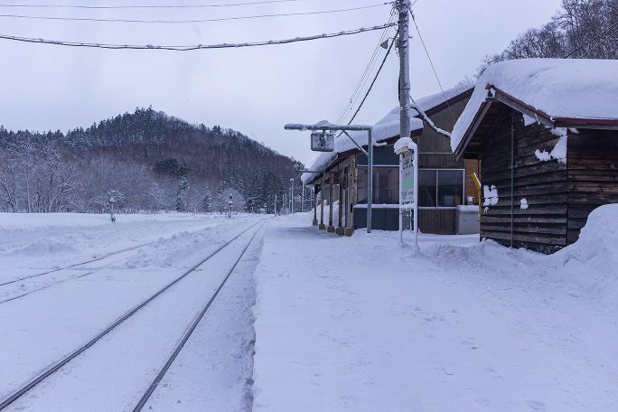 雪に埋もれながら列車の到着を待つ峠下駅