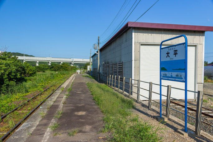 保線車両用の車庫を備えた大平駅の向こうに東北新幹線の高架が見える