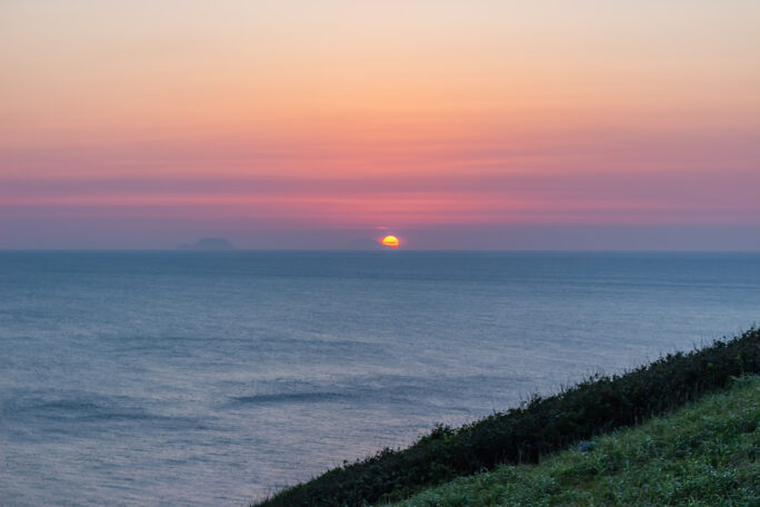 渡島小島と渡島大島の島影をかすめて太陽が津軽海峡に沈んでいく