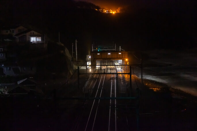 駅を見下ろす高台の吹き曝しで孤独に通過列車を待つ