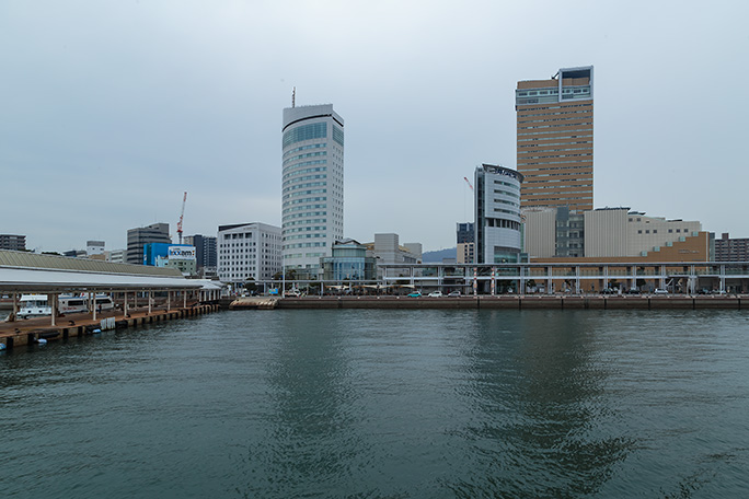 近代的なビルが立ち並ぶ市街地を眺めながら高松港内で旋回