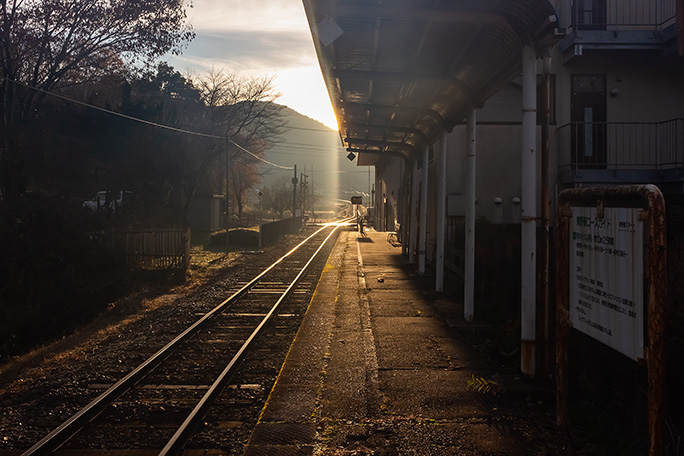朝日に輝く鉄路が印象的な東野駅