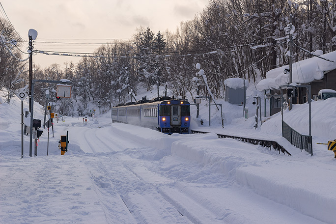 雪の塩狩駅を通過していく特急「サロベツ」