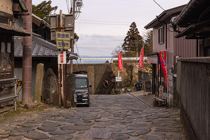 峠の茶屋向こうで信貴生駒スカイラインを潜り抜けて降っていく奈良県側の峠道を振り返る