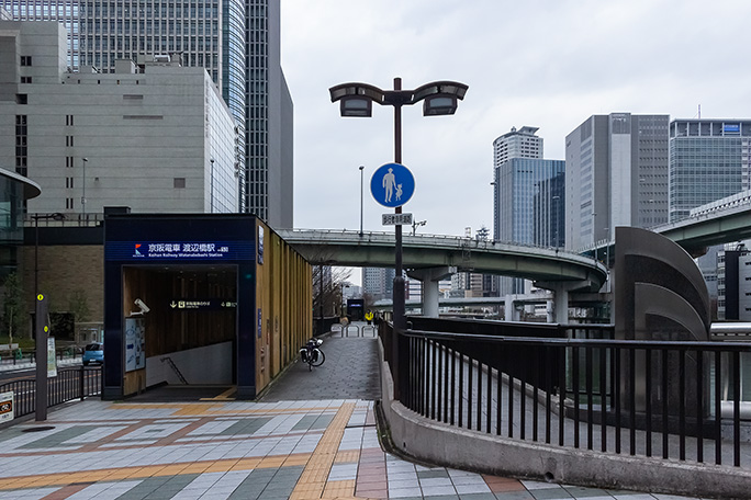 高層ビル群の間を高架高速道路が縫うように走る都市景観の中にある渡辺橋駅