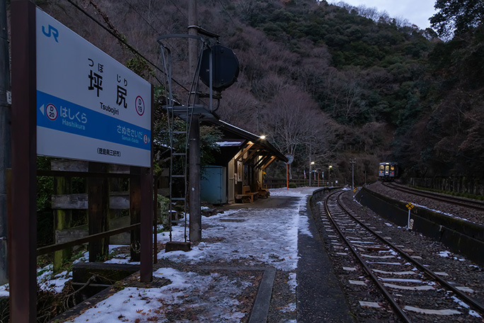 坪尻トンネルに消えていく始発列車の後姿を見送る