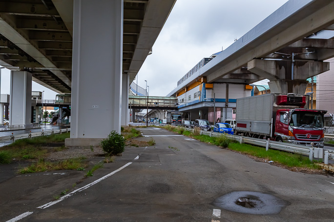 首都高速と横浜シーサイドラインの下の交通量の多い道を通って南部市場駅を通過