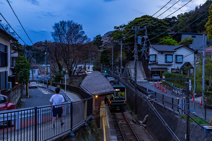 暮れなずむ極楽寺駅を出発していく江ノ電