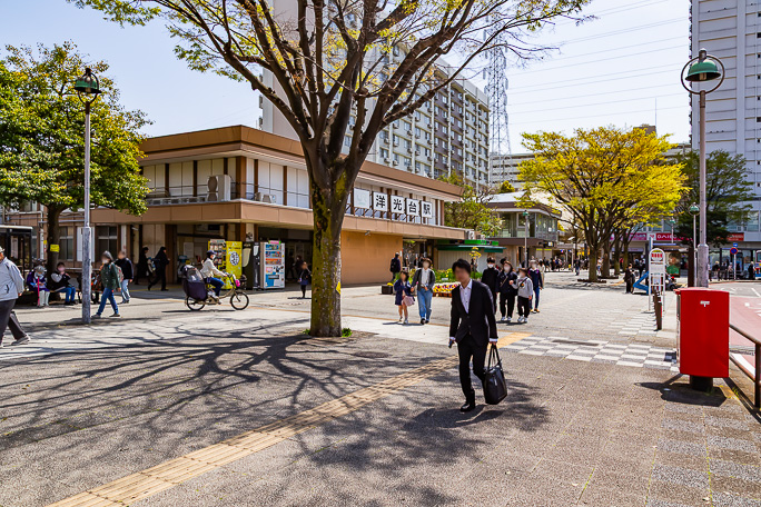 街路樹の植わった駅前に多くの人が集う洋光台駅