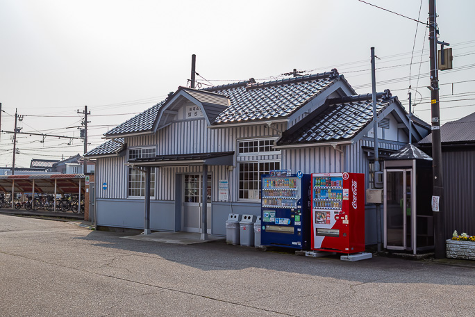 開業当時の社名と駅名の右書き表札が掲げられた越中三郷駅舎