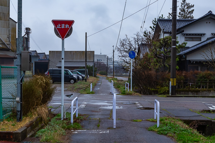 津沢駅跡は津沢駅児童公園となっていて、この標識左側のフェンス内の公園がその跡地だった