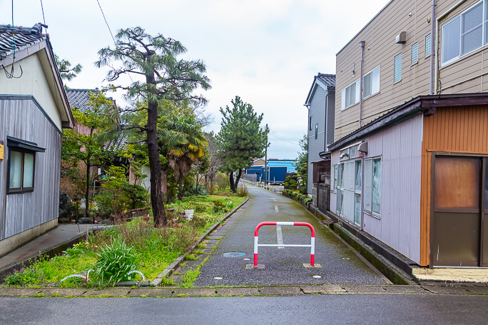 このサイクリングロードが線路跡で右手の建物付近に新港東口駅の駅舎があった